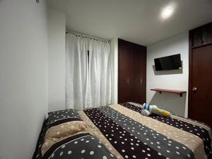 a bedroom with a bed with black and white polka dots at Tayra Living Suites in Mocoa