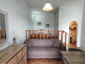 a living room with a couch and a staircase at Aneraida Studio in Sikinos