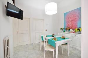 ポリニャーノ・ア・マーレにあるAffittacamere A Pochi Passiの白いキッチン(青いテーブルと椅子付)