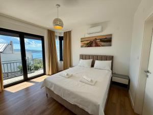 Un dormitorio con una cama blanca con una ventana grande. en Villa V, en Crikvenica 51 fotos más