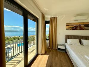 Un dormitorio con una cama y un balcón con vistas. en Villa V, en Crikvenica