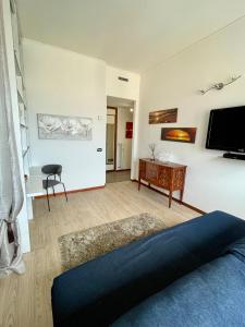 ein Wohnzimmer mit einem Sofa und einem Fernseher an der Wand in der Unterkunft Skyline Genova Centro in Genua