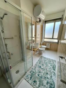 ein Badezimmer mit Glasdusche und Toilette in der Unterkunft Skyline Genova Centro in Genua + 13 Fotos