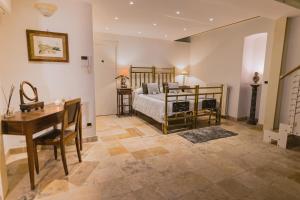 a bedroom with a bed and a table and a desk at Sassi Suite - Elegant Historic Home in Matera