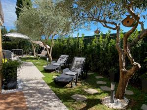 een tuin met twee stoelen en een boom bij Piccolo Sogno in Desenzano del Garda