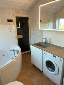 Un baño con lavadora y lavabo. en Ferienhaus Möwenstübchen Grömitz, en Grömitz