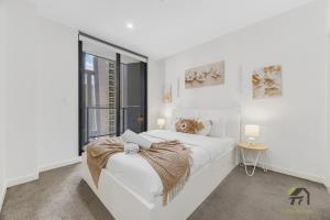 Un pat sau paturi într-o cameră la Parramatta Sunshine City Nest