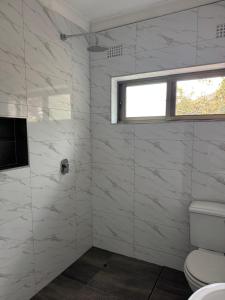 a white bathroom with a toilet and a window at Shiwa riverside apartment 