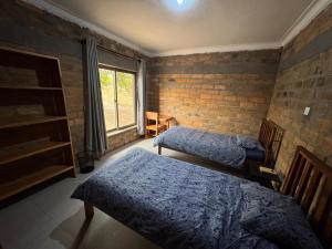 a bedroom with two beds and a brick wall at Shiwa riverside apartment 