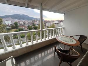 ein Balkon mit Tisch und Stühlen und einem großen Fenster in der Unterkunft ROYAL 52 in Altınordu