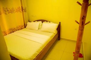 a small bedroom with a bed with white sheets and pillows at Novaland Hotel Rw in Kigali