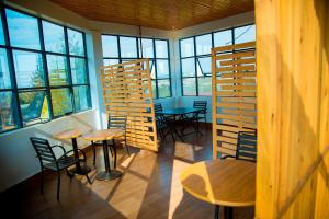 a room with tables and chairs and windows at Novaland Hotel Rw in Kigali