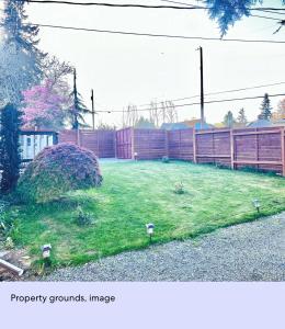 a yard with a fence and some lights in the grass at Ember Loft in Everett +2 photos