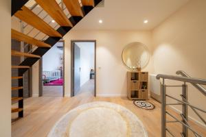 a hallway with a staircase and a mirror on the wall at La Maison de Rania - Moins dun km de la gare in Tourcoing +18 photos