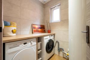 a laundry room with a washing machine and a window at La Maison de Rania - Moins dun km de la gare in Tourcoing