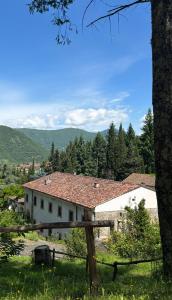 a white house with a fence and mountains in the background at Convento del Carmine 4 in Fivizzano +4 photos