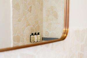 a mirror in a bathroom with three bottles on a shelf at Boutique B&B Villa Gufo in Ostuni +61 photos