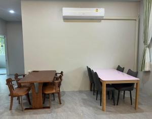 a room with two tables and chairs and a air conditioner at KohmakHomeHug Homestay in Ko Mak