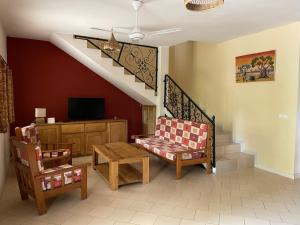 a living room with a chair and a table and a staircase at Villa Warang in Mbour