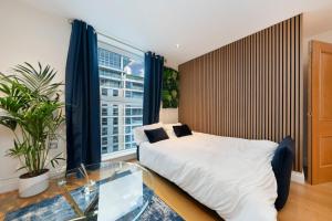 a bedroom with a bed and a large window at Chelsea Thames View Suite in London