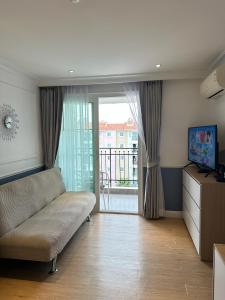 a living room with a couch and a sliding glass door at Seven Seas Cote d'Azur D807 - 1 bedroom Cozy apartments in a premium Condo near the sea Бронирование открыто in Na Jomtien