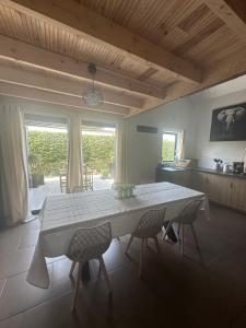 a kitchen with a table and chairs in a room at L’Escale du lac in Brêmes