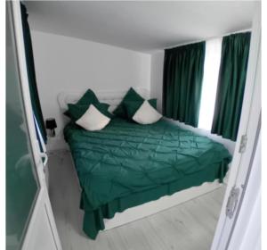 una camera da letto con un letto con lenzuola e cuscini verdi di Casuța Râului a Zărneşti
