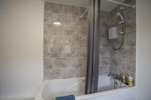 a bathroom with a shower and a bath tub at Cosy Home in Grimsby Town Centre in Grimsby +42 photos