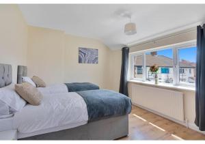 a bedroom with two beds and a window at Modern & Spacious 3BR Free Parking Enfield North London in Enfield +23 photos