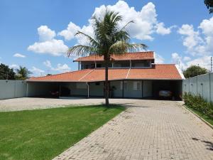 a house with a palm tree in the driveway at Chácara Nova Aliança,Paulínia- São Paulo in Paulínia
