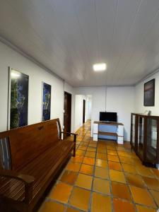 Sala de estar con banco y TV en Jack Beach House, en Palhoça