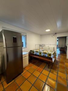 Habitación con nevera y cama. en Jack Beach House, en Palhoça