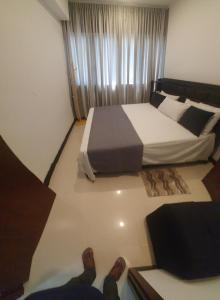 a bedroom with a bed and a person with their feet on the floor at Trizen luxury apartments Colombo Sri lanka in Colombo