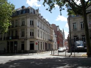a street in a city with buildings and a car at Au Cœur De Lille in Lille