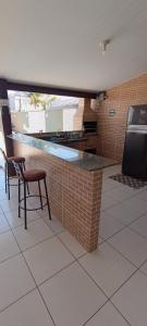 a kitchen with a brick counter with a table and chairs at Sua casa com piscina em Sinop, próximo ao shopping e UFMT in Sinop