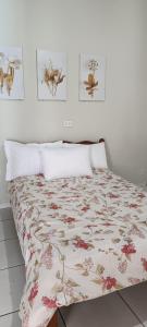 a bedroom with a bed with a floral bedspread at Sua casa com piscina em Sinop, próximo ao shopping e UFMT in Sinop