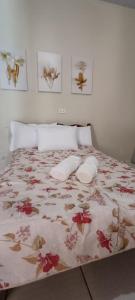 a bedroom with a bed with a floral bedspread at Sua casa com piscina em Sinop, próximo ao shopping e UFMT in Sinop