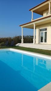 a swimming pool in front of a house at Casa Condor - Moradia com piscina a 5 min da praia in Lourinhã