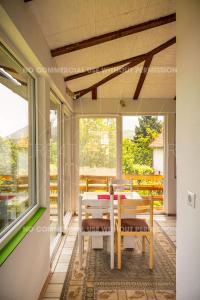 a dining room with a table and chairs on a porch at Cottage Eminem with garden and view of Sarajevo in Hadžići