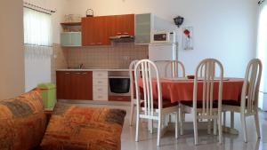 a kitchen with a table and chairs in a room at Apartments Mareta in Rab
