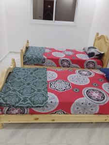 Monte ʼArrouitتجزئة الهناء العروي的两张带毯子和枕头的床