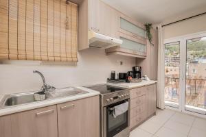 a kitchen with a sink and a stove top oven at Filoxenia City Apartment in Zakynthos Town