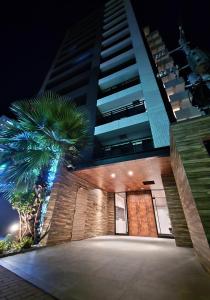 a building with a palm tree in front of a building at Buena Vista Ohori Park in Fukuoka