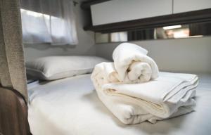 a pile of towels sitting on top of a bed at JR Autocaravanas in Las Puntas