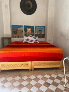 - une chambre avec un grand lit et un couvre-lit rouge dans l'établissement Dar Sarsar Artistic Music, à Marrakech