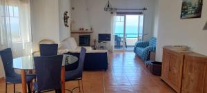 una sala de estar con una mesa y un sofá en Páteo na Ericeira, en Ericeira