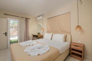a bedroom with a bed with white sheets and a window at Filoxenia City Apartment in Zakynthos Town