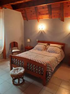una camera con letto e struttura in legno di Gite le Marronnier a Saint-Mamet-la-Salvetat
