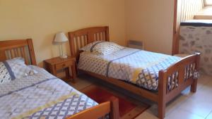 una camera da letto con due letti e un tavolo con una lampada di Gite le Marronnier a Saint-Mamet-la-Salvetat