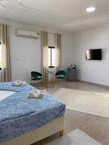 a hotel room with two beds and a flat screen tv at Arabian Nights Nook in Muscat